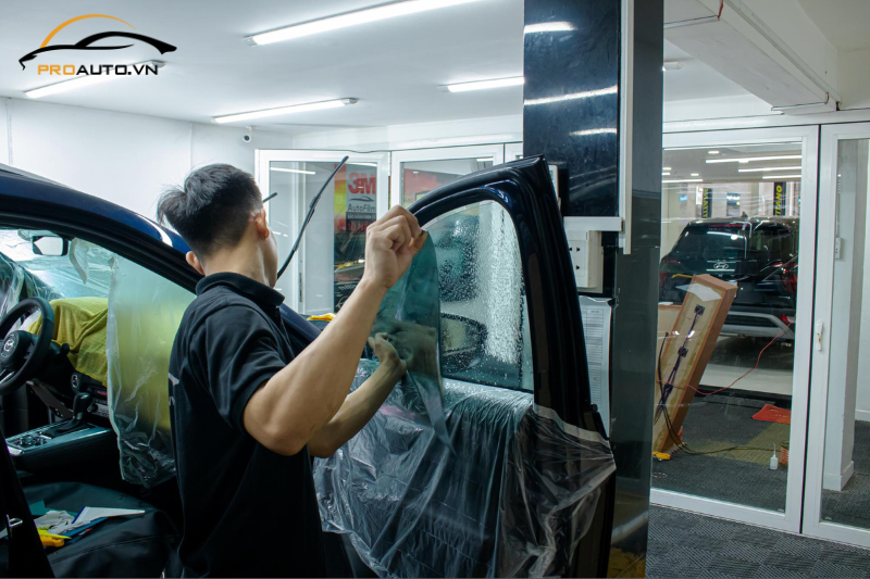Kỹ thuật viên dán phim cách nhiệt cho kính tài phụ 
