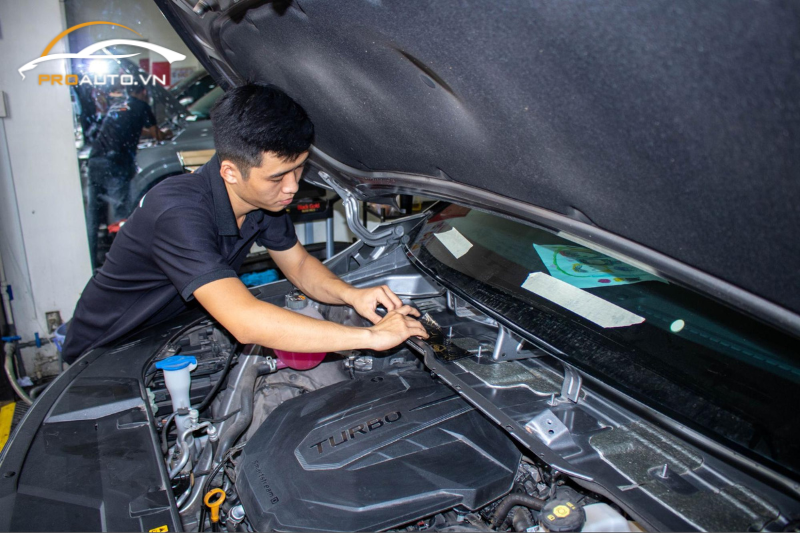 Kỹ thuật viên thi công dán cách âm cho khoang máy xe hơi