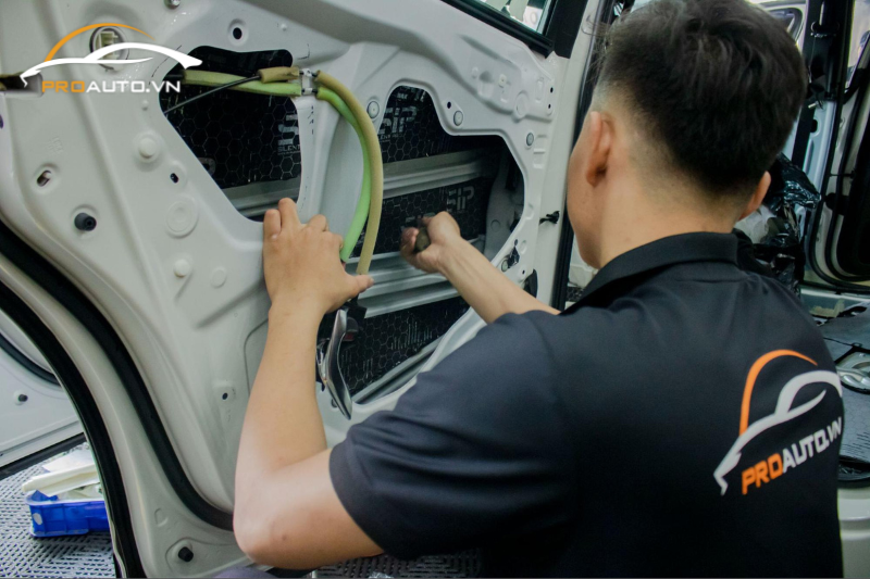 Kỹ thuật viên thi công dán cách âm chống ồn xe Toyota Vios