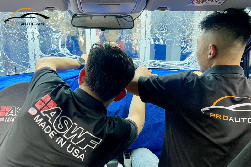 Kỹ thuật viên thi công dán phim cách nhiệt cho kính lái xe hơi