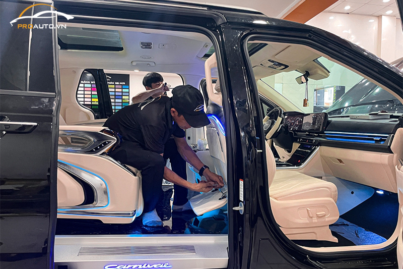 Kỹ thuật viên thi công lắp đặt bàn xếp cho xe Kia Carnival