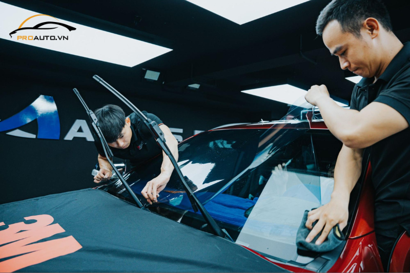 Kỹ thuật viên thi công dán phim cách nhiệt cho kính lái xe hơi