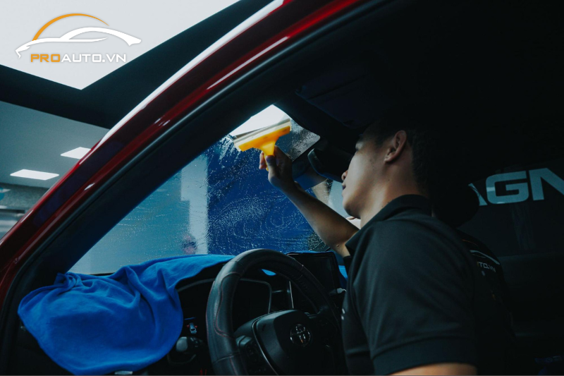 Kỹ thuật viên thi công dán phim cách nhiệt 3M cho kính lái