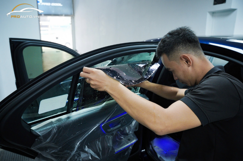 Kỹ thuật viên thi công dán phim cách nhiệt cho kính sườn xe