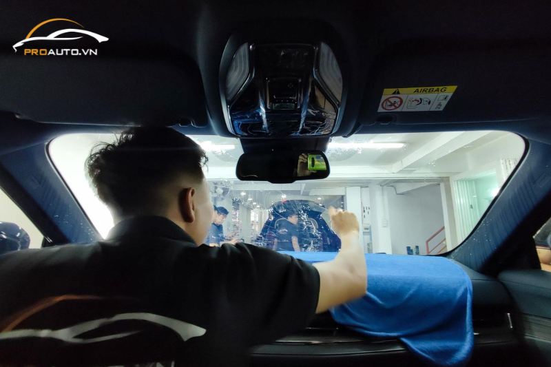 Kỹ thuật viên thi công dán phim cách nhiệt kính lái ô tô